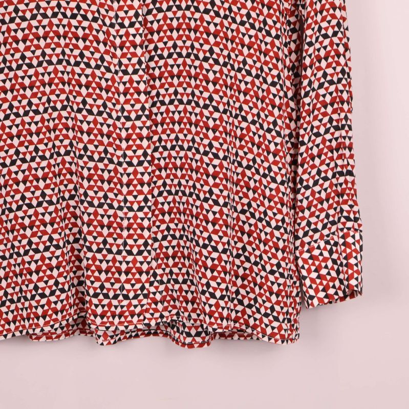 Nedre del av blus med grafiskt mönster och långa ärmar
