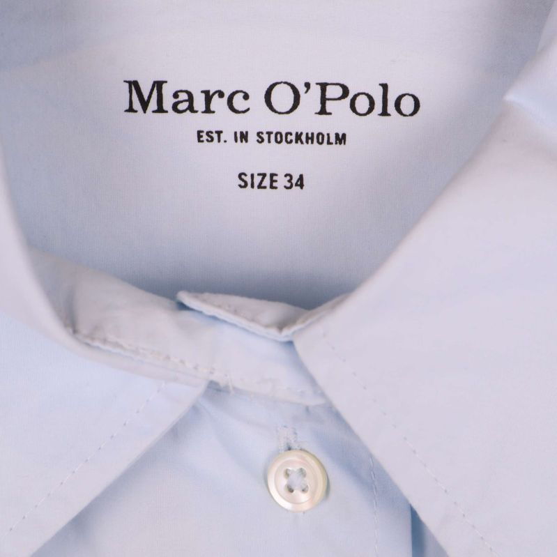 Närbild av krage med Marc O'Polo logotyp samt storlek 34