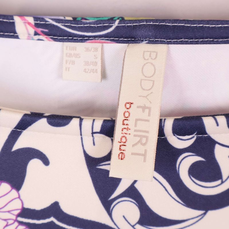 Klänningsetikett med texten BODYFLIRT boutique nära halsringning