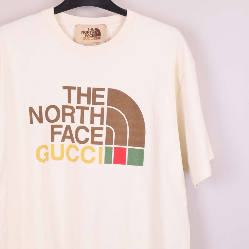 Detaljbild på logotyptrycket The North Face Gucci på bröstet
