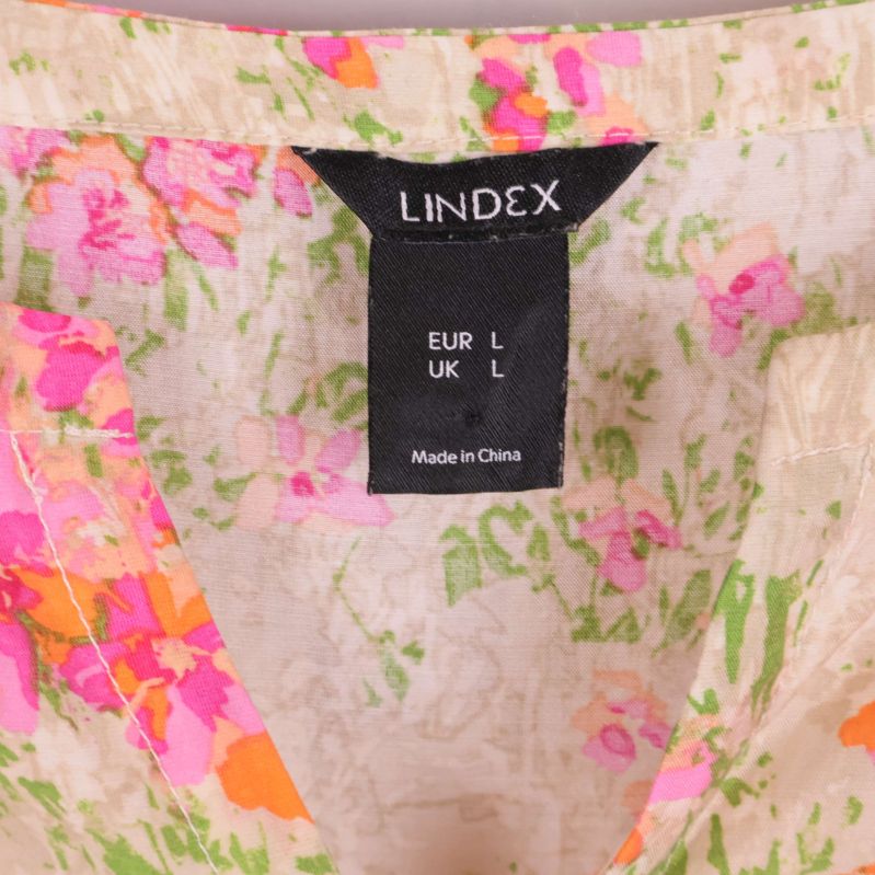 Närbild på Lindex-märke i halsen på blommig blus