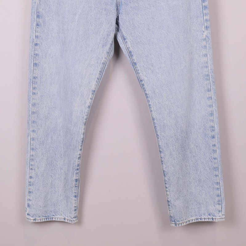Nederdel av raka benen på ljusblå jeans