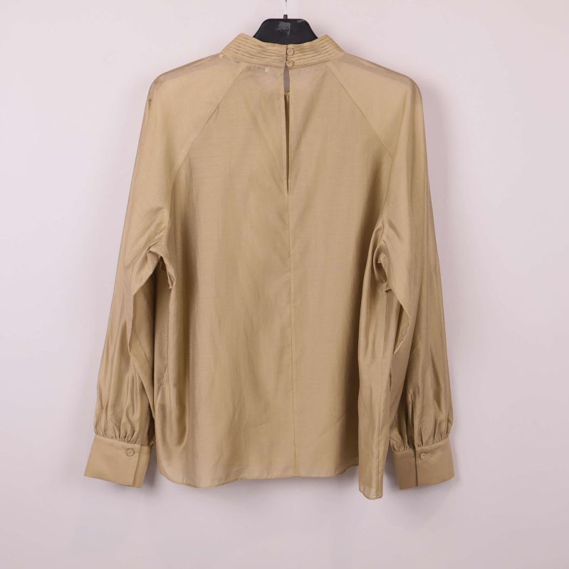 Baksidan av beige blus med dragkedja i nacken