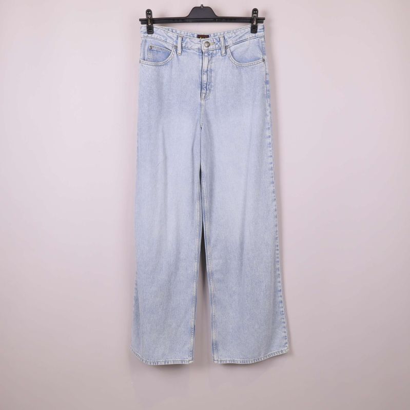 Ljusa A-linje jeans upphängda framifrån mot ljus bakgrund