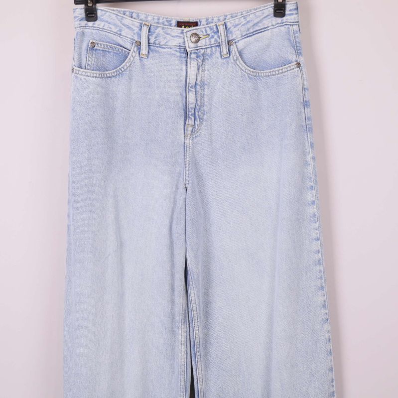 Midjeområdet och överdelen på ljusa jeans upphängda