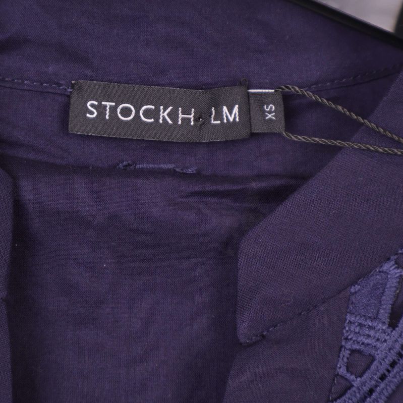 Etikett med Stockholm LM-logga på lila textil
