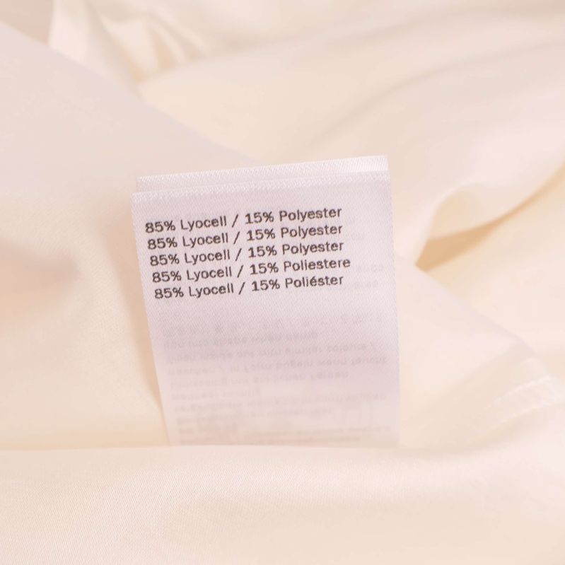 Materiallapp som visar 85% lyocell och 15% polyester