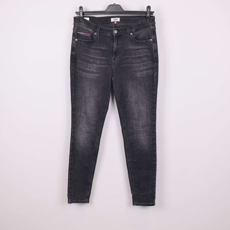 Framsida på svarta smala jeans upphängda mot vit bakgrund
