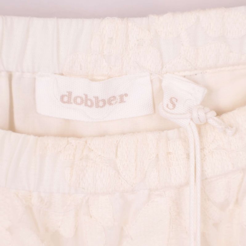 Närbild på dobber-logotyp samt resårmidja med dragsko