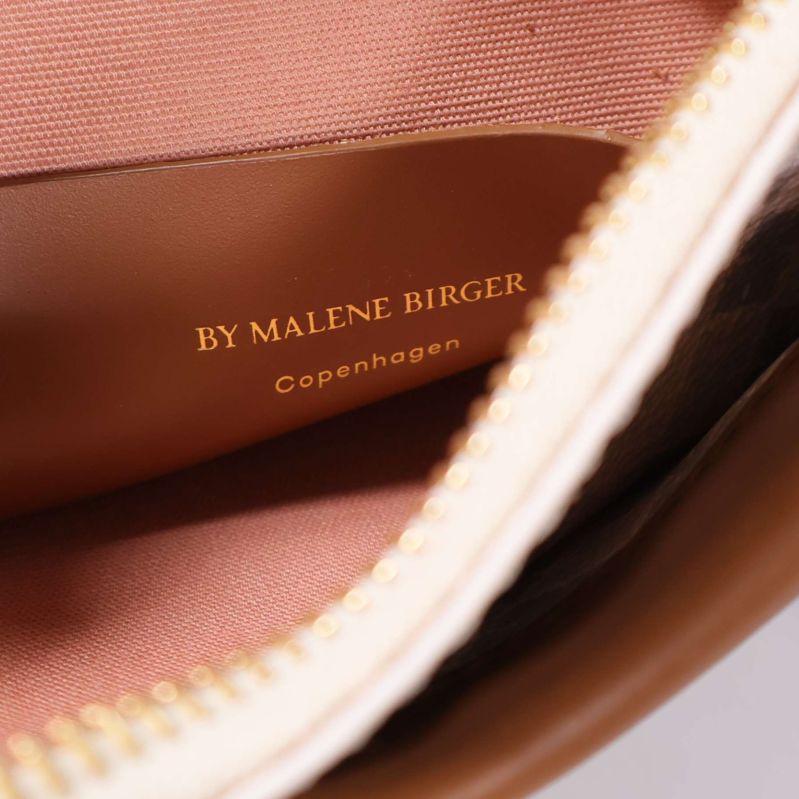 Närbild inuti väskan med text By Malene Birger