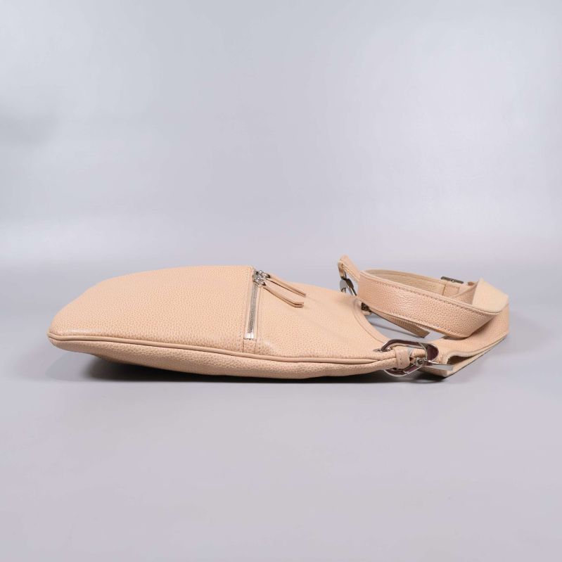 Beige väska liggande, visar slimmad profil