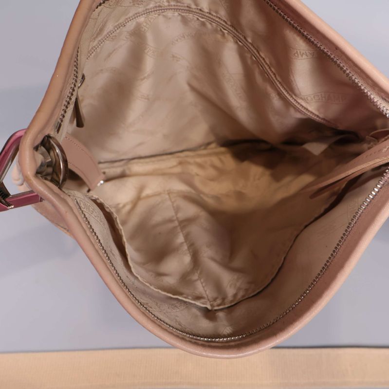 Insidan av beige axelremsväska med innerfickor