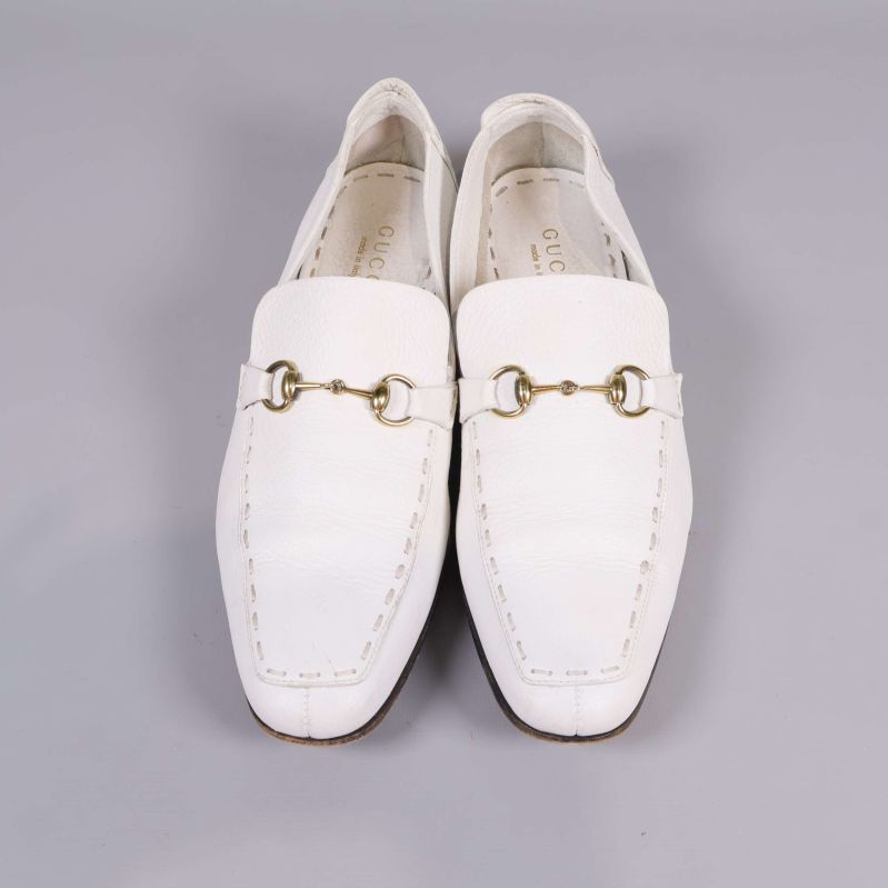 Vita loafers från Gucci fotograferade rakt framifrån