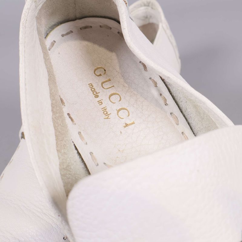 Närbild på Gucci-logotyp inuti vit loafer