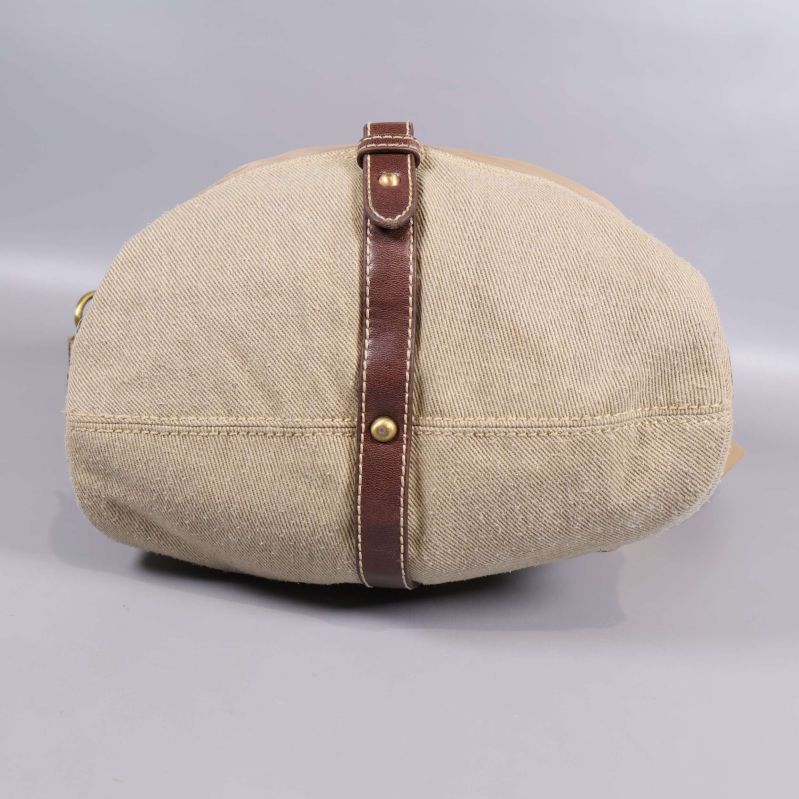 Botten av beige väska med bruna detaljer och grov textil