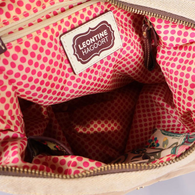 Detalj på insidan av väska med rosa prickigt foder och Leontine Haggoort-märke