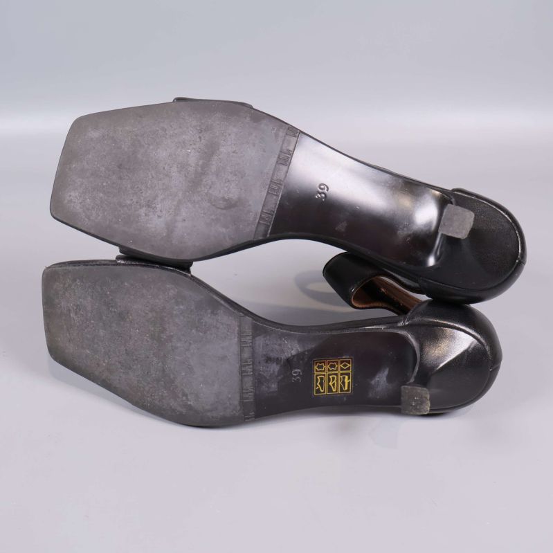 Sandaler med slitna sulor och storleksmärkning under
