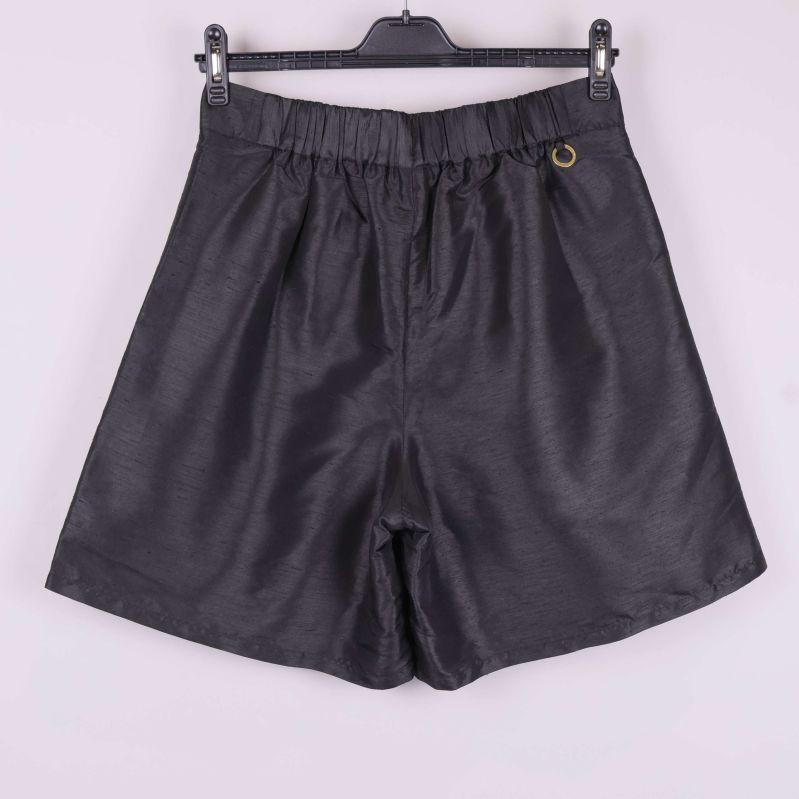 Baksida på svarta shorts med resår och metallsmycke