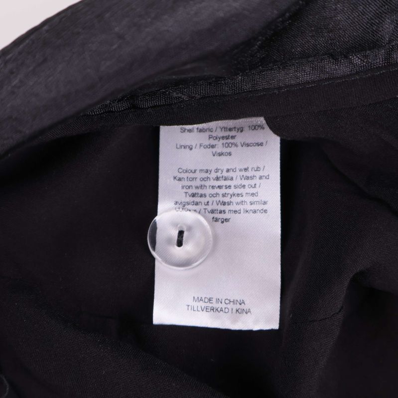Materiallapp inuti shortsen med knapp