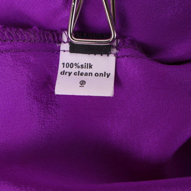 Materiallapp med text 100% silk dry clean only