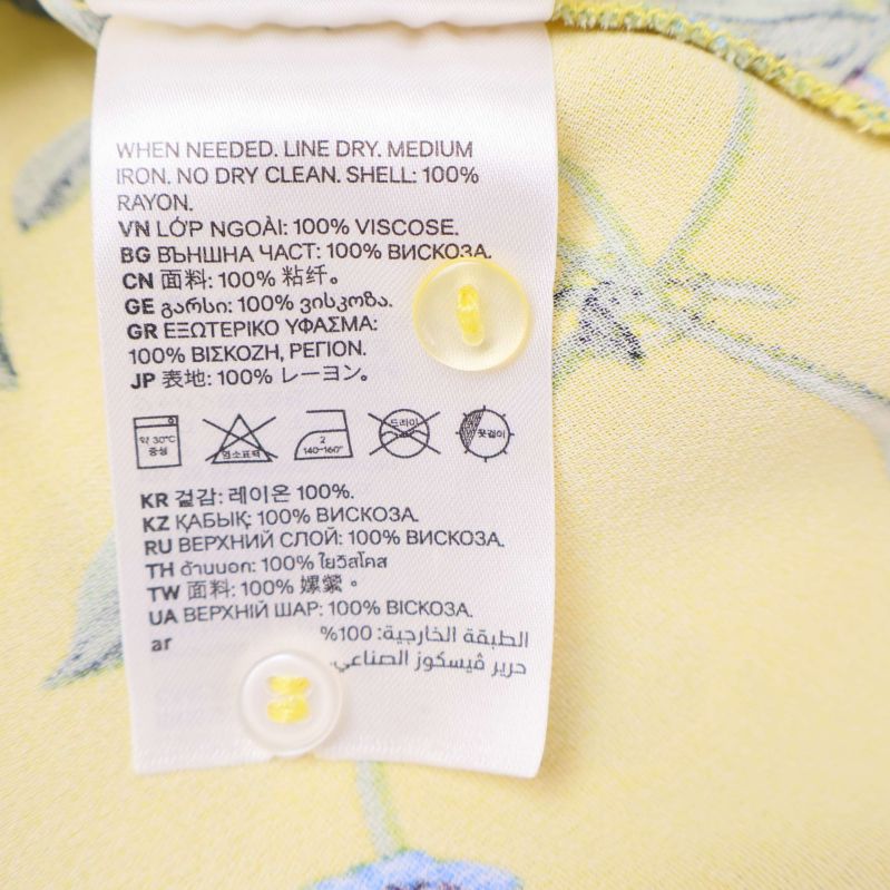 Materiallapp på gul klänning med extra knapp insydd