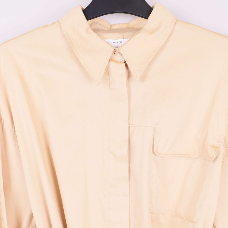 Detaljbild av bröstficka på beige skjortklänning