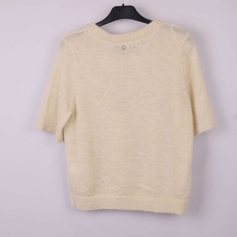 Baksida av beige stickad topp på galge