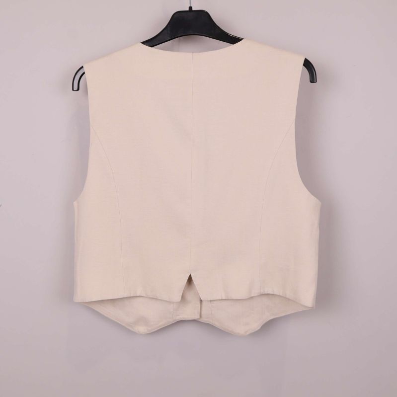 Baksidan av beige väst med liten slits nertill