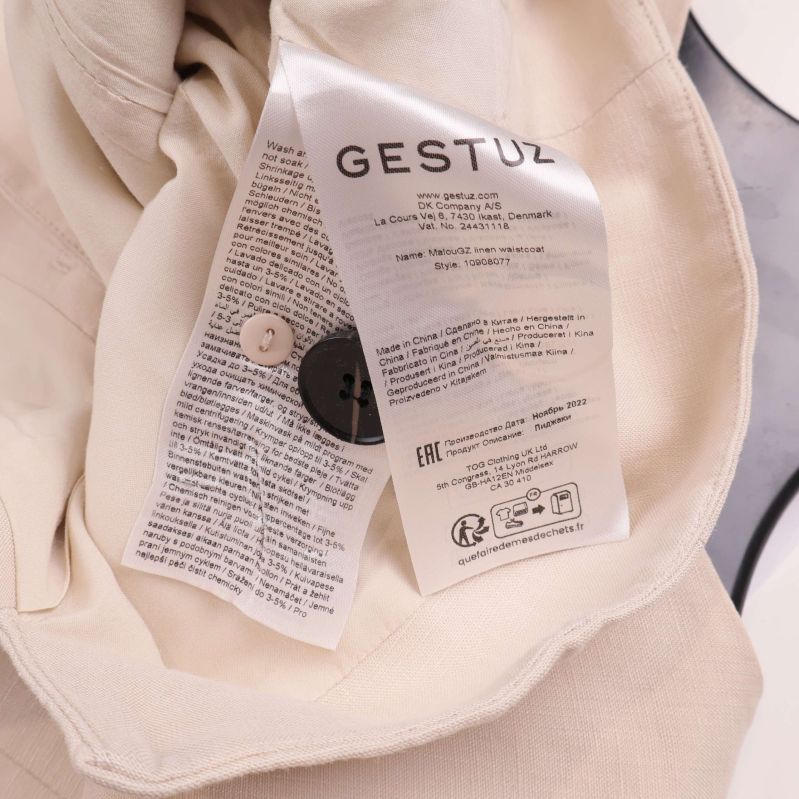 Material- och tvättrådsetikett för Gestuz väst invändigt