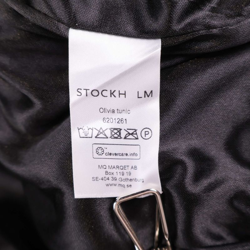 Inneretikett med tvättråd och produktnamn Olivia tunic