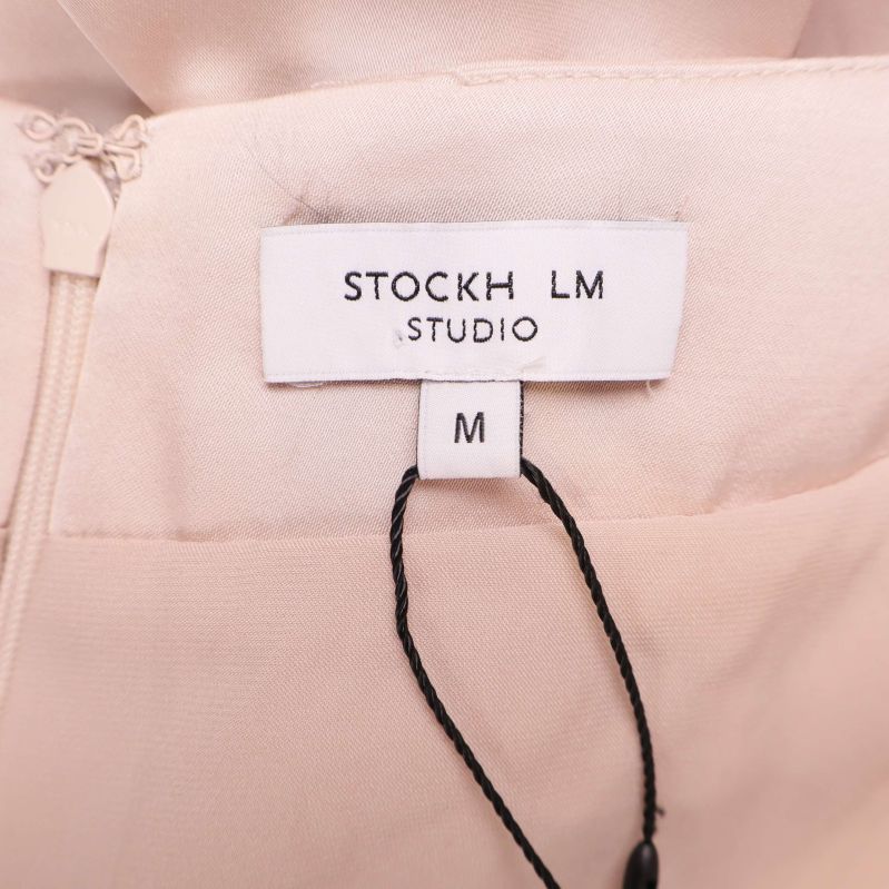 Närbild på etikett med texten STOCKH LM STUDIO och storleken M