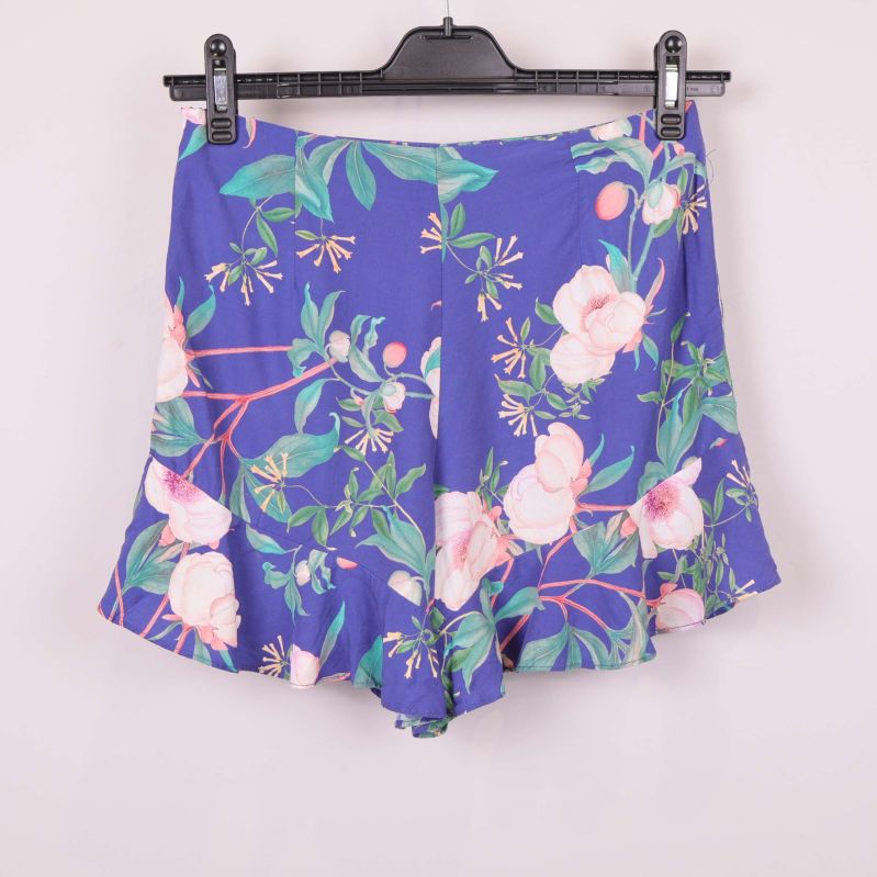 Baksidan av blå shorts med blommönster och volanger