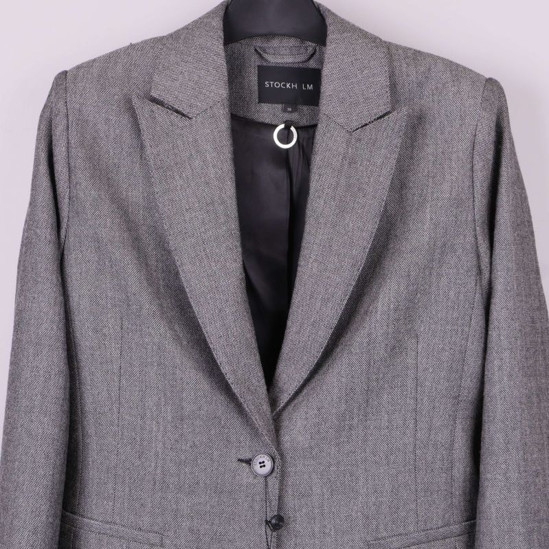 Närbild på blazer med etiketten STOCKH LM synlig i nacken