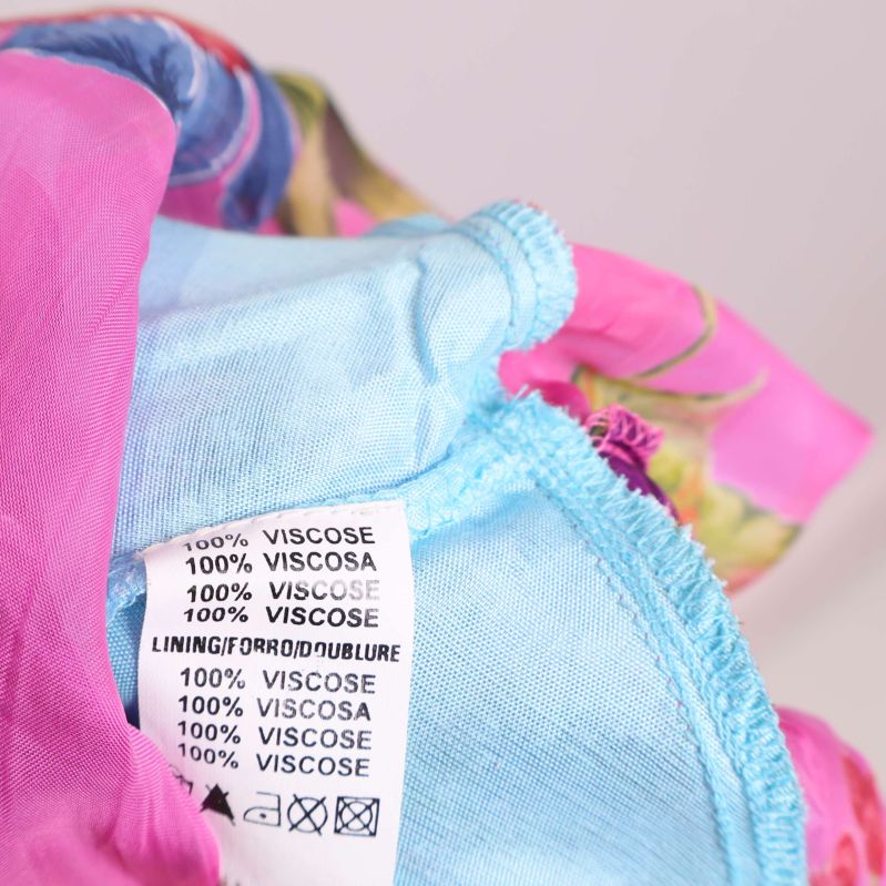 Materiallapp med texten 100% viskosa, både yttertyg och foder