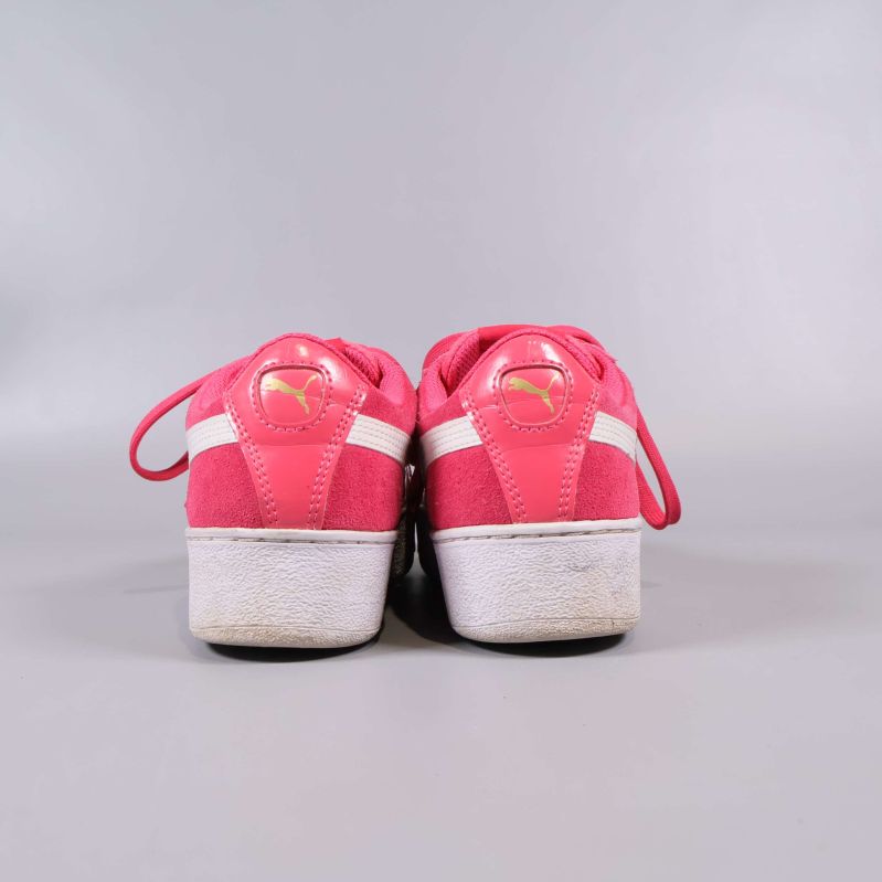 Baksida på rosa sneakers med gul Puma-logga