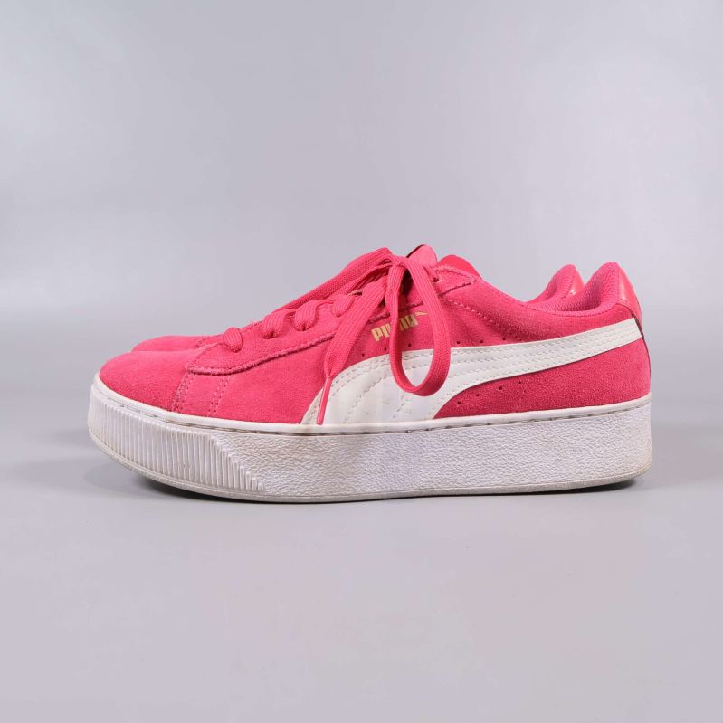 Sida av rosa sneakers med vit Puma-logga