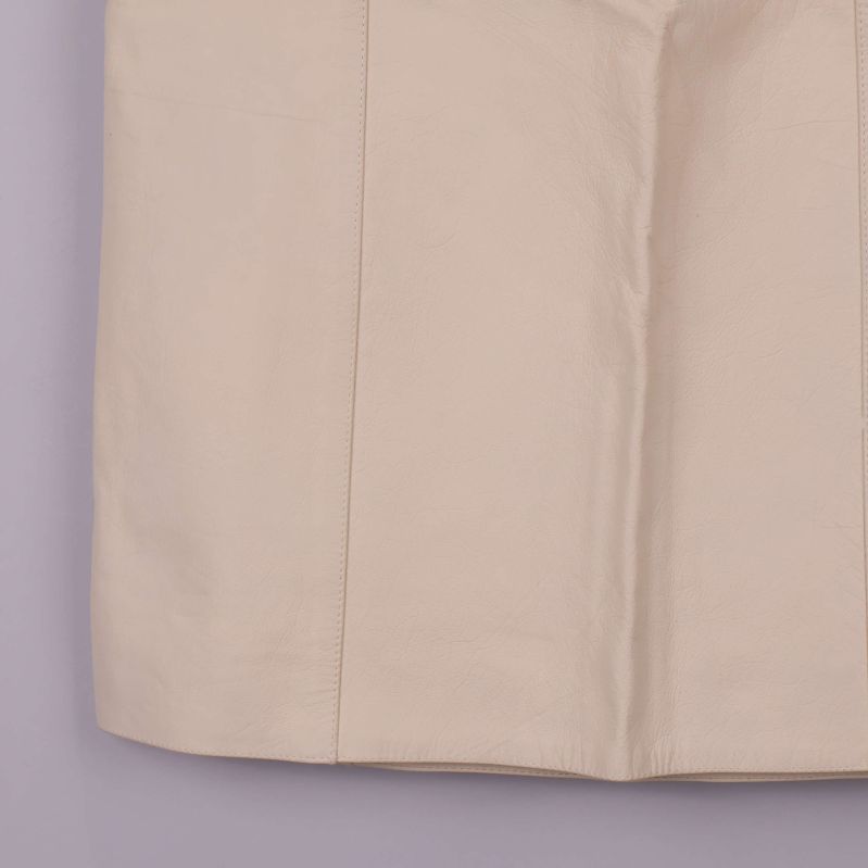 Närbild på nedre delen av beige pennkjol