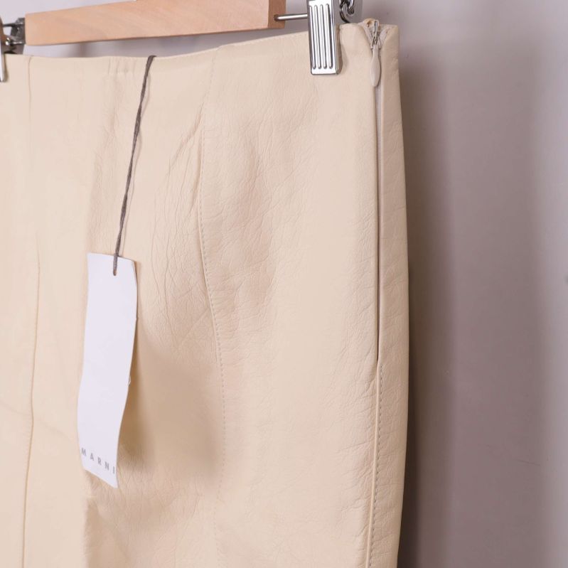 Sidoöppning och struktur på beige pennkjol i läder