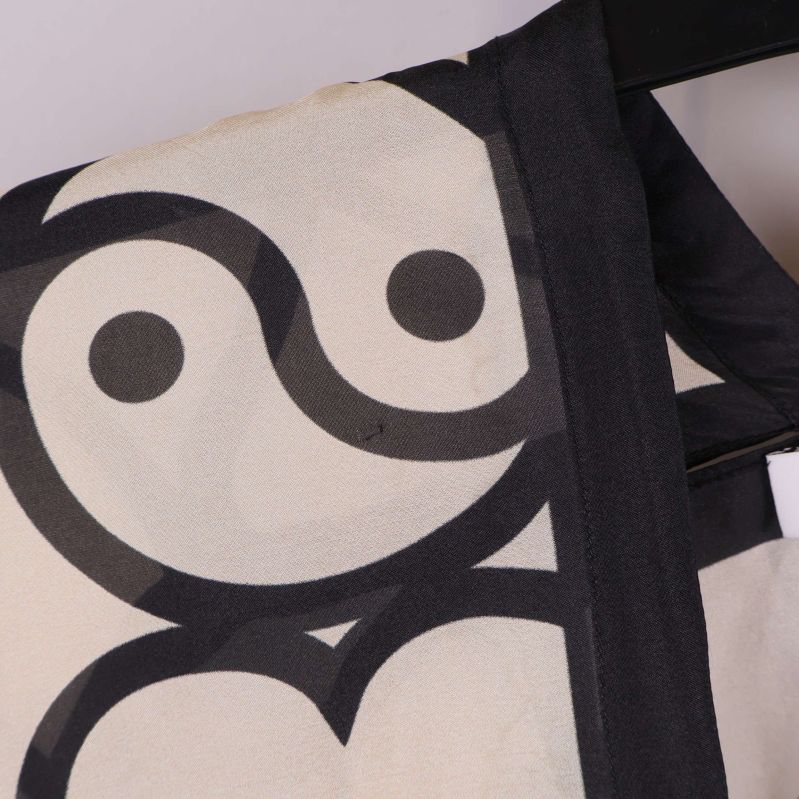 Närbild av axelparti med yin-yang-symbol på kaftan