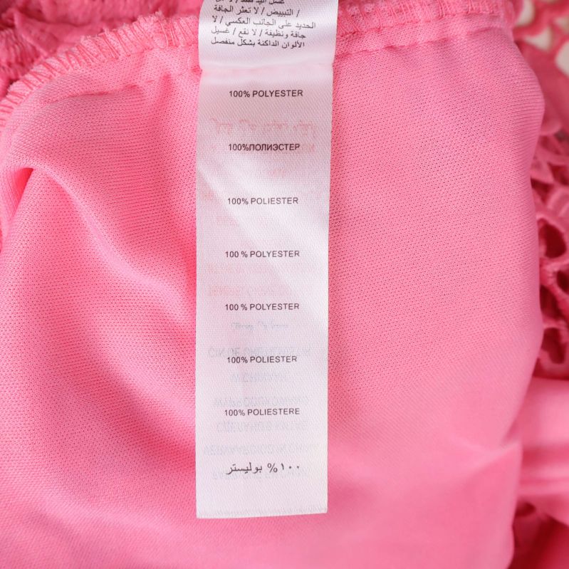 Materialetikett visar 100% polyester på insidan av klänningen