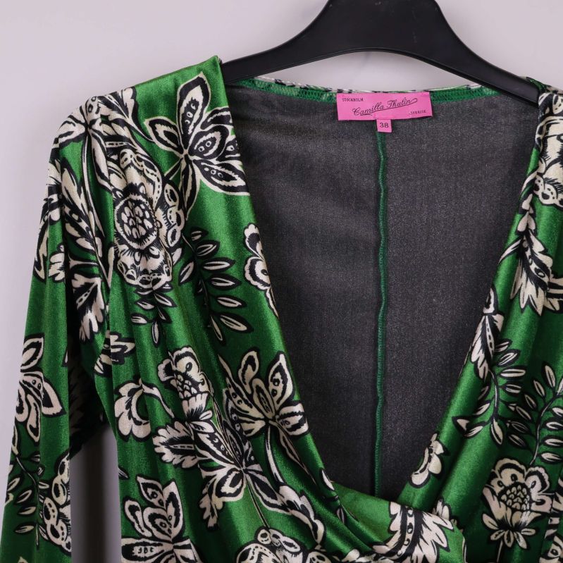 Närbild på urringningen och draperingen på blusens framsida
