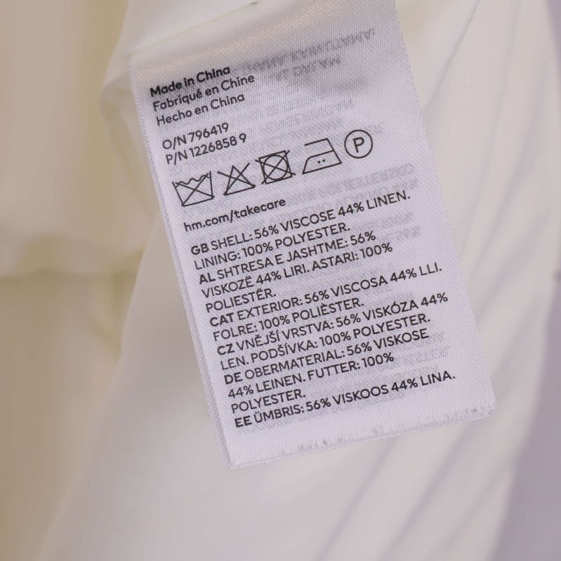 Tvättrådsetikett med materialinformation på flera språk