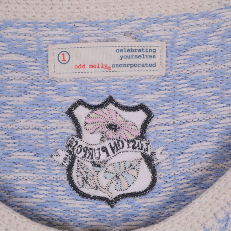 Insida av cardigan visar broderad badge och Odd Molly-etikett