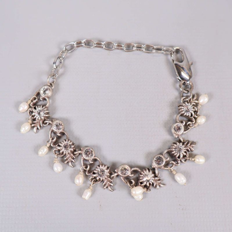 Armband med hängande vita pärlor och blommotiv i silverfärg