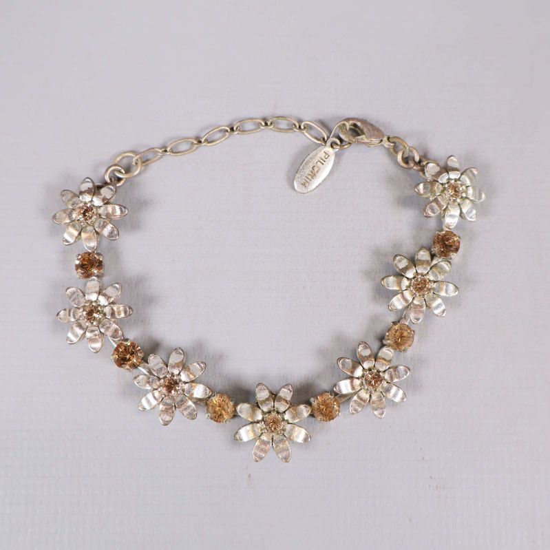 Armband med blommor och bruna detaljer i närbild