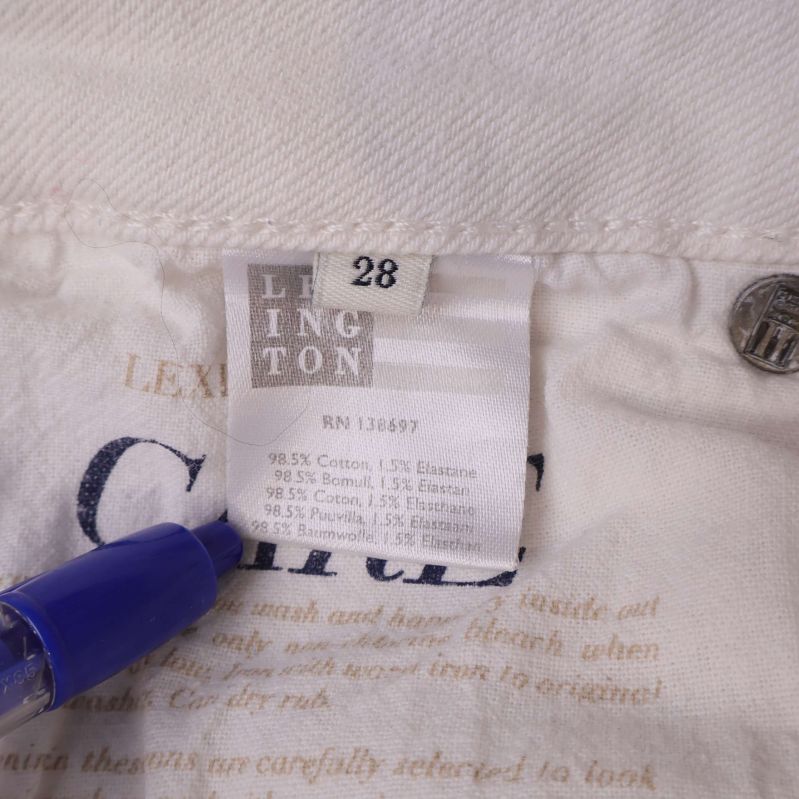 Material- och storleksetikett med texten 98,5% bomull, 1,5% elastan