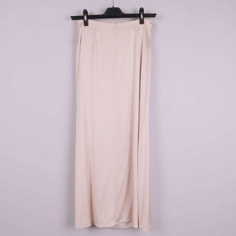 Baksidan av lång beige kjol som hänger på galge