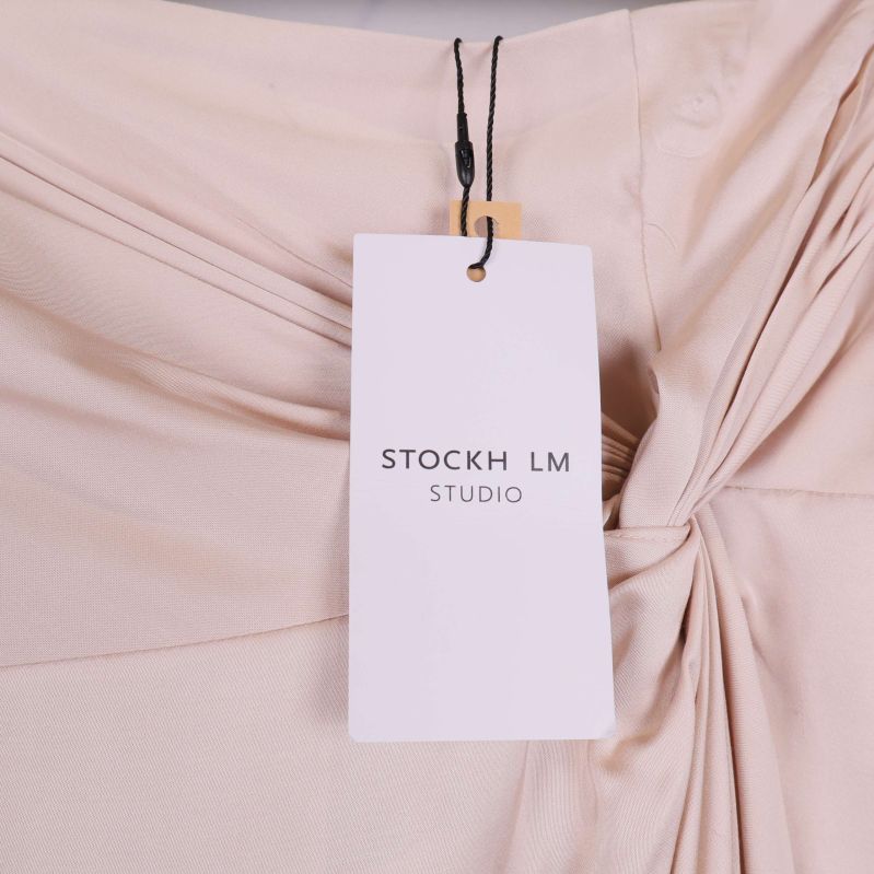 Närbild på Stockh LM Studio etikett fastsatt i midjan