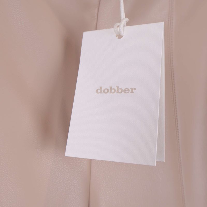Närbild på vit hangtag med dobber-logotyp på byxorna