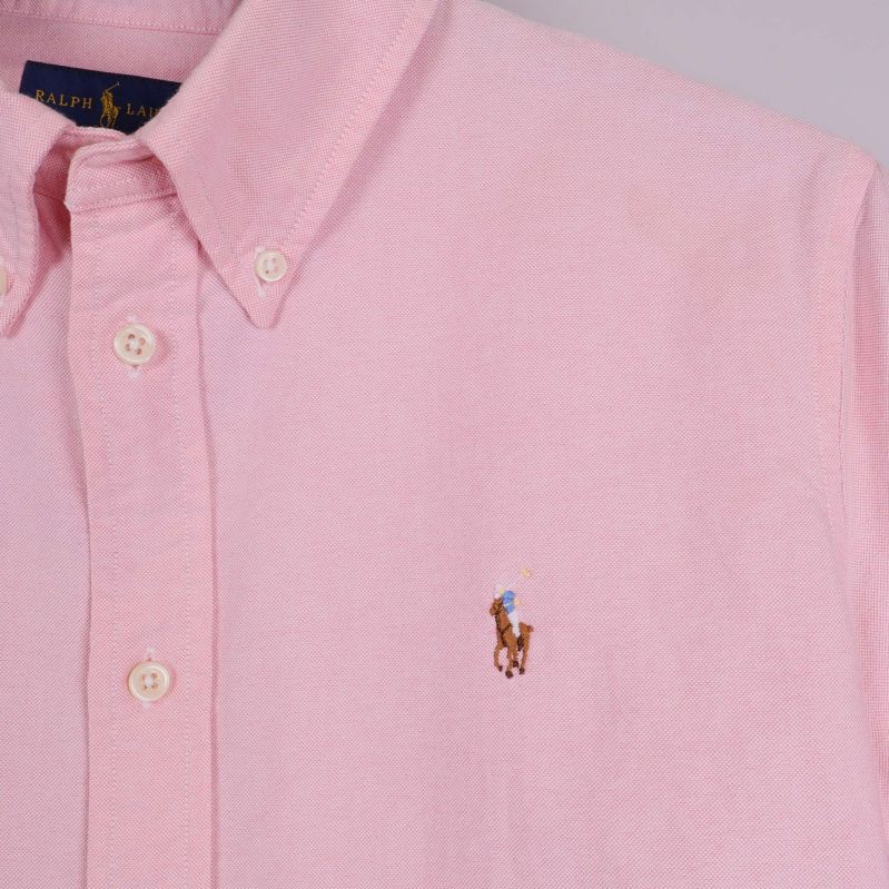 Närbild på bröstlogo och krage på rosa skjorta